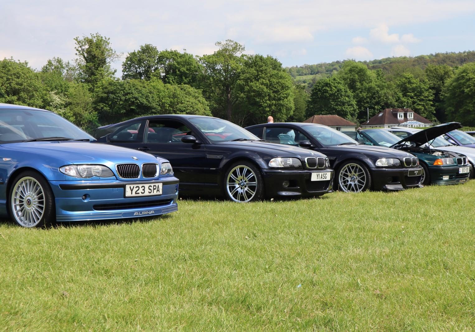 Black BMW E46 M3 coupe among a line-up of BMWs at a car gathering