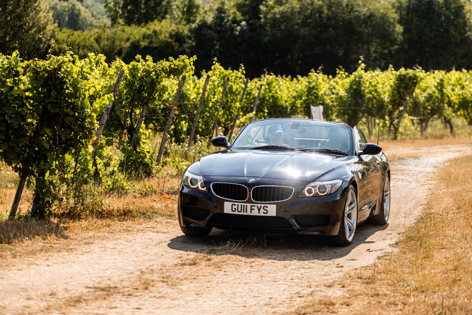 BMW E89 Z4 roadster with the roof down beside vineyard rows