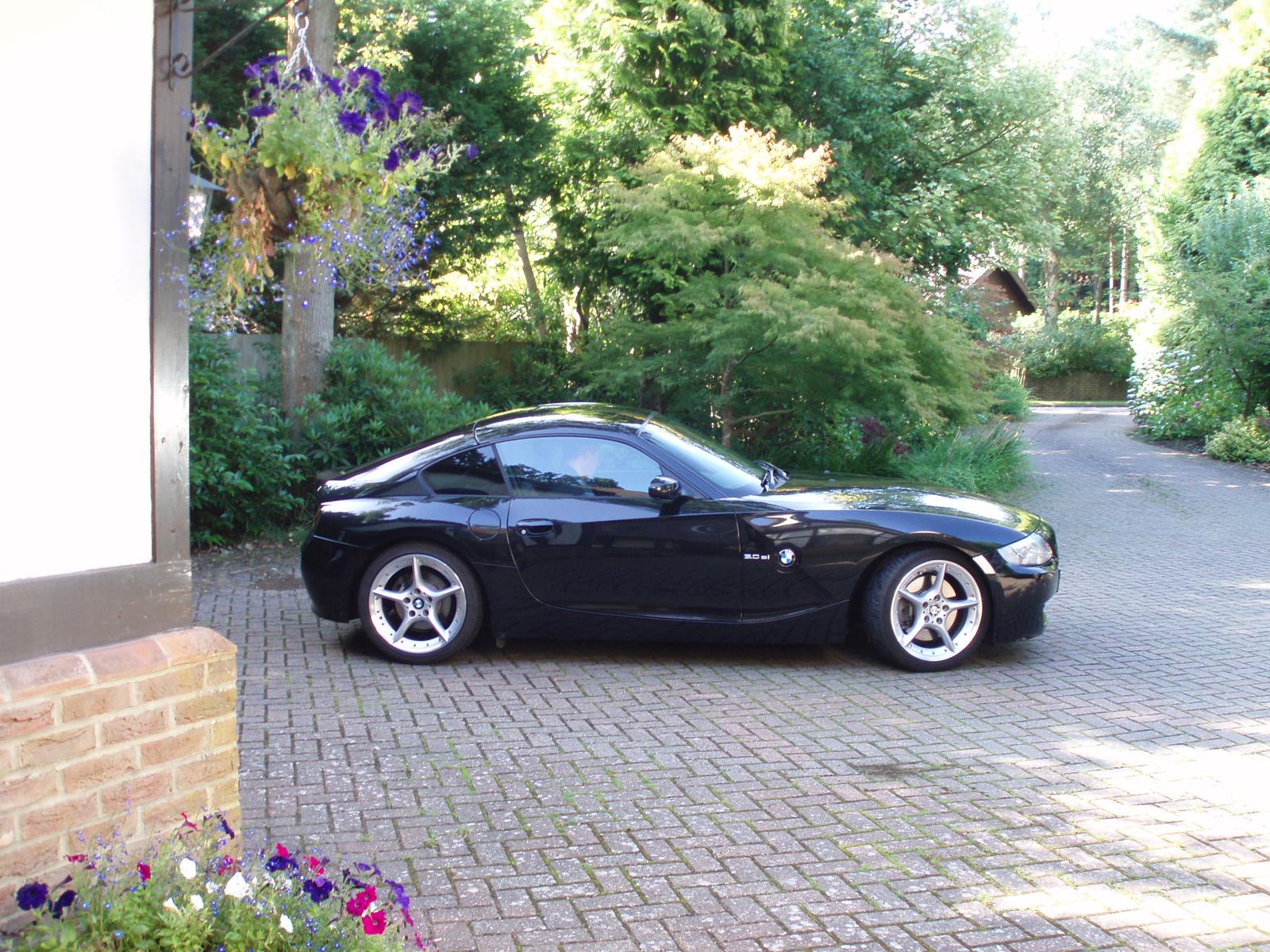 Black BMW E86 Z4 coupe in side profile on a driveway